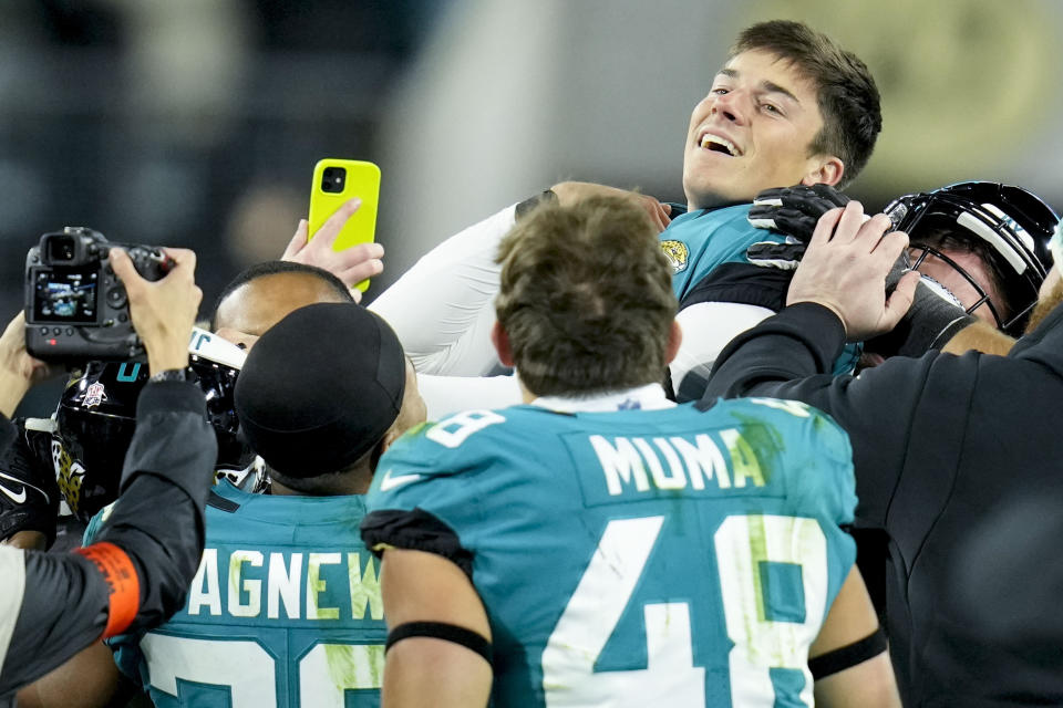 Jacksonville Jaguars place kicker Riley Patterson, top right, and his team celebrate his game-winning field goal against the Los Angeles Chargers during the second of an NFL wild-card football game, Saturday, Jan. 14, 2023, in Jacksonville, Fla. Jacksonville Jaguars won 31-30. (AP Photo/John Raoux)