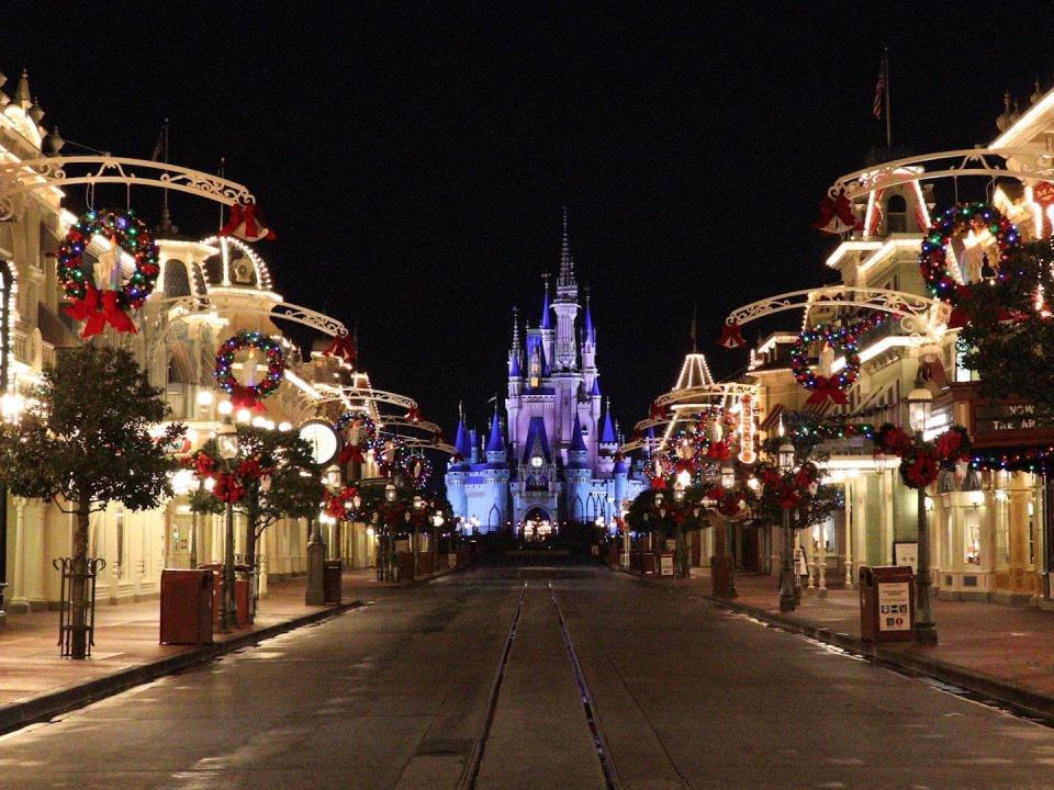 main street usa in magic kingdom at disney world lit up at night with christmas decorations