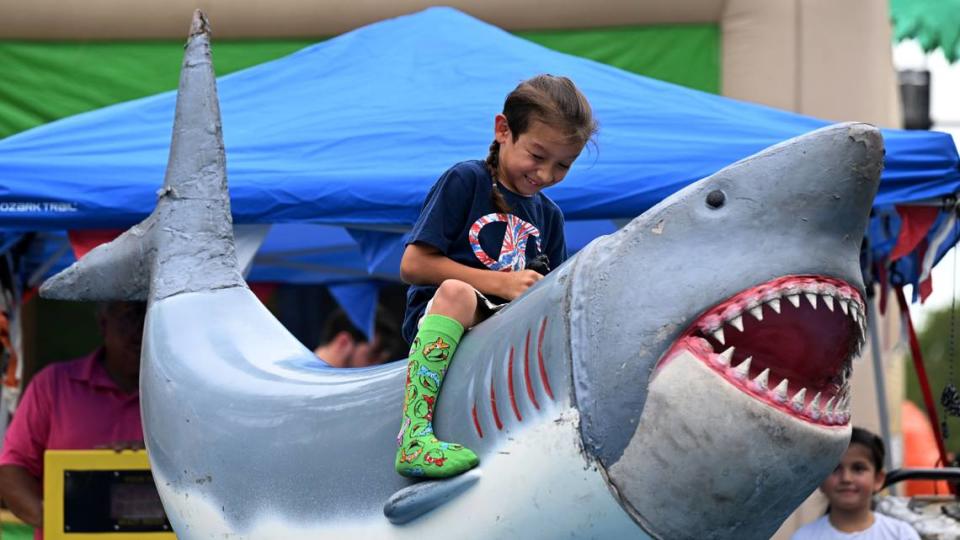 A child enjoys the shark ride at the block party before the DeSoto Parade on Saturday, April 27, 2024.