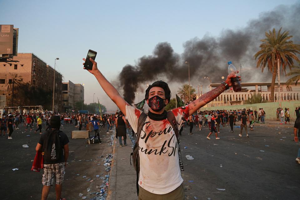 Anti-government protesters set fires and close a street during a demonstration in Baghdad, Iraq, Thursday, Oct. 3, 2019. Iraqi security forces fired live bullets into the air and used tear gas against a few hundred protesters in central Baghdad on Thursday, hours after a curfew was announced in the Iraqi capital on the heels of two days of deadly violence that gripped the country amid anti-government protests that killed over 19 people in two days. (AP Photo/Hadi Mizban)