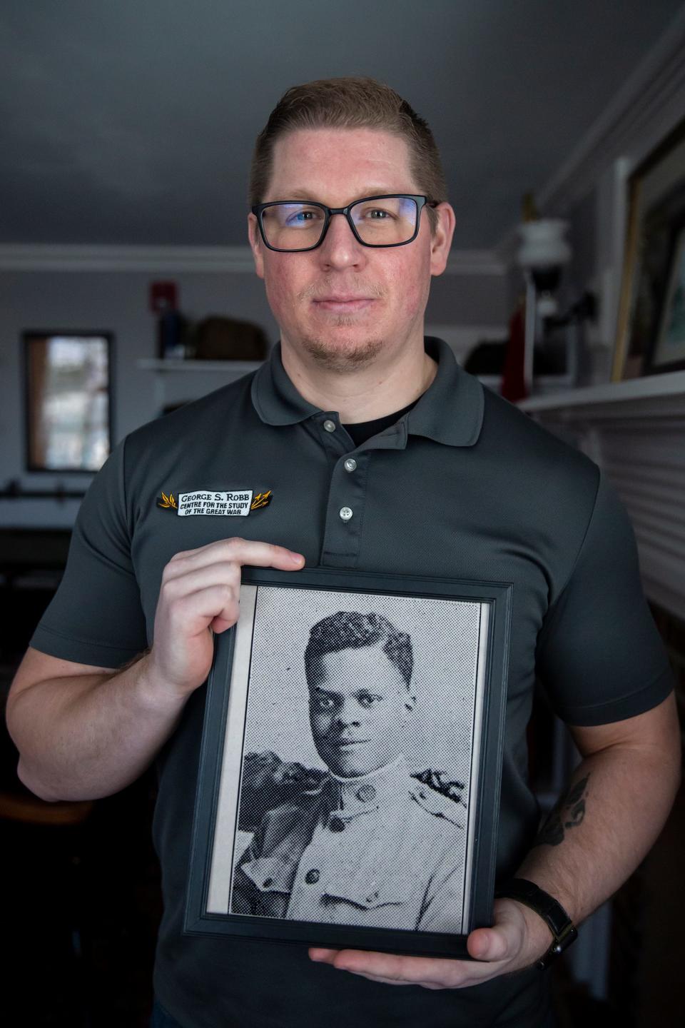 Josh Weston, senior military analyst at the George S. Robb Centre, holds a photo of U.S. Army 2nd Lt. Rufus Jackson.