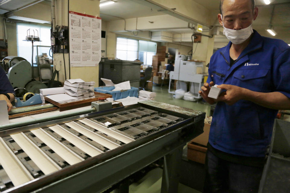 A worker puts together matchbooks as they are produced on an assembly line at a Nittosha factory in Himeji, Japan, Wednesday, June 29, 2022. Nittosha, a small Japanese manufacturer, is stopping the production of matchbooks. The company, which employs 130 people, is a testament to the hard work and dedication at small and medium-size companies that are the backbones of large economies, including the U.S. and Japan. (AP Photo/Yuri Kageyama)