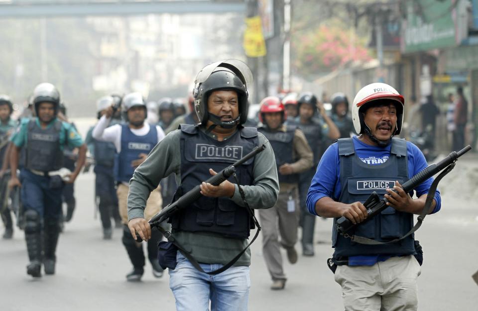 Members of police run during a clash with the activists of Bangladesh Jamaat-E-Islami in Dhaka