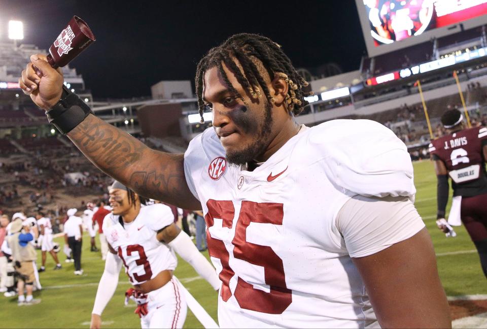 Alabama Crimson Tide offensive lineman JC Latham (65) celebrates his team's win over Mississippi State 40-17 with a cow bell in Davis Wade Stadium at Mississippi State University in Starkville, Miss., on Sept. 30, 2023.