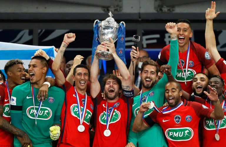 Paris Saint-Germain's Maxwell (C) holds the trophy as he celebrates winning the French Cup final football match against Angers (SCO) on May 27, 2017, at the Stade de France in Saint-Denis