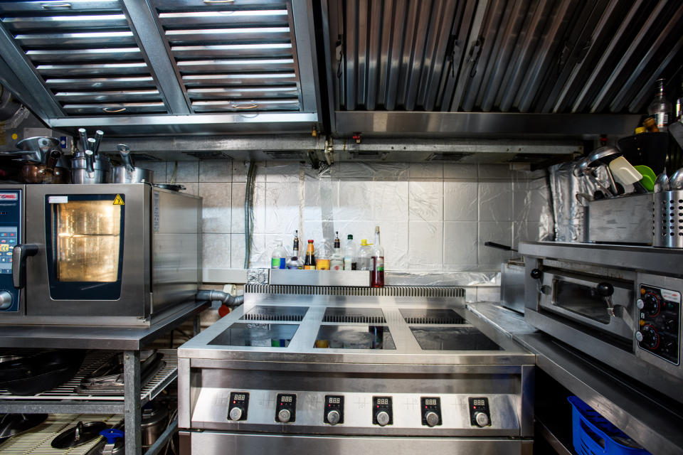 The interior of this modern restaurant kitchen includes an electric stove and oven