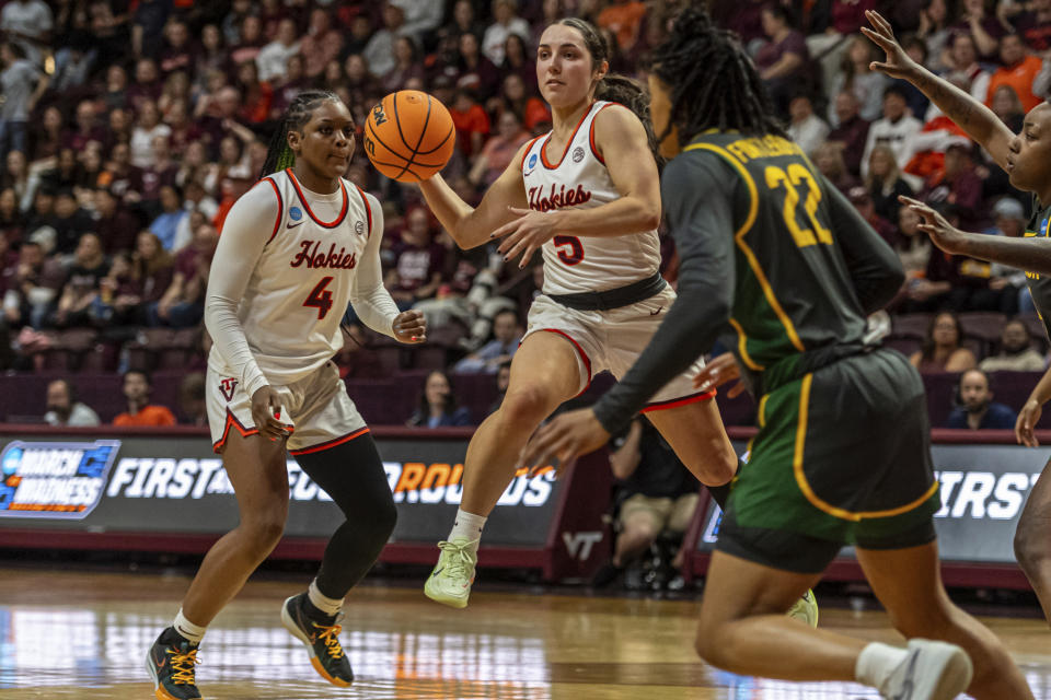 Virginia Tech's Georgia Amoore, center, passes against Baylor's Bella Fontleroy during the second half of a second-round college basketball game in the women's NCAA Tournament in Blacksburg, Va., Sunday, March 24, 2024. (AP Photo/Robert Simmons)