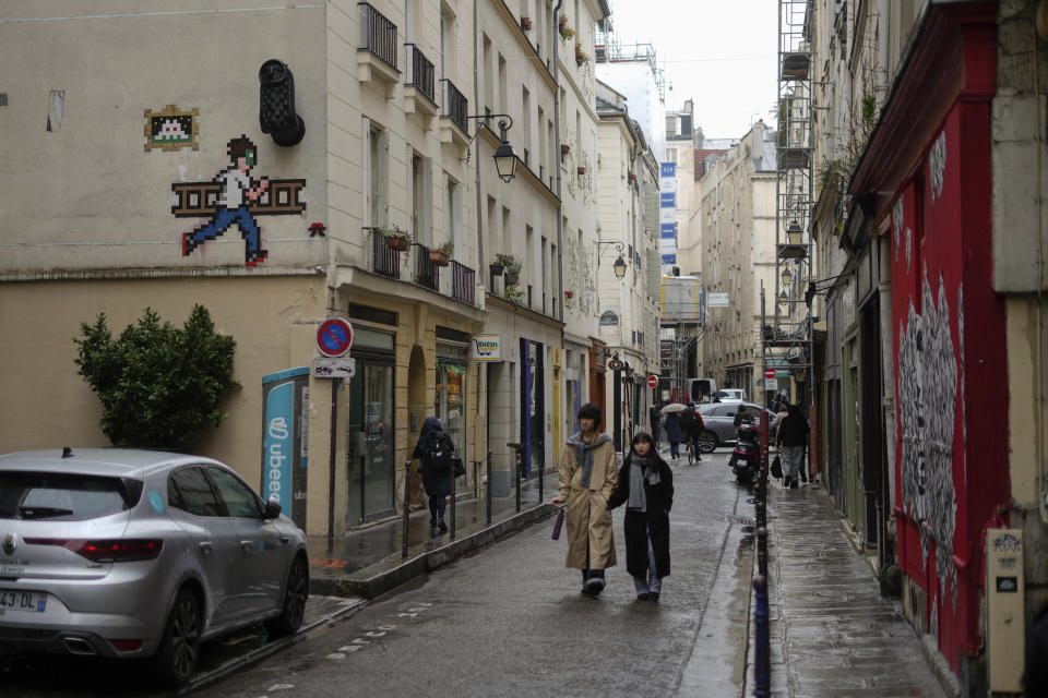 Un mosaico del artista francés Invader, arriba a la izquierda, en una calle de París el jueves 29 de febrero de 2024. Invader, uno de los artistas franceses más internacionales, ha pegado mosaicos en las paredes de la capital francesa, el mundo e incluso los ha llevado a la Estación Espacial Internacional. (Foto AP/Thibault Camus)