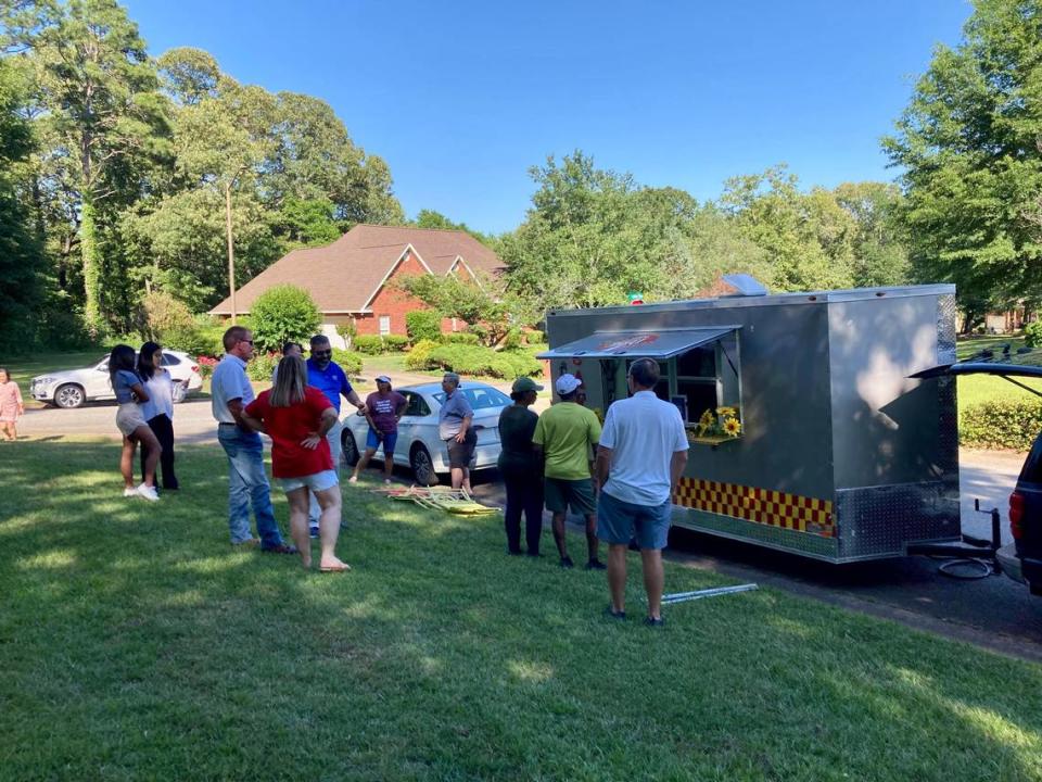 People line up at the Signature Flavors Cafe & Catering food truck at The Brantley subdivision Wednesday in Warner Robins.