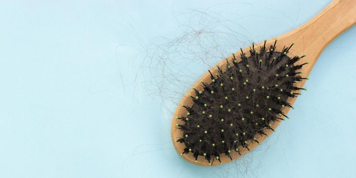 comb with hair on a blue background, the problem of hair loss, the concept of hair care