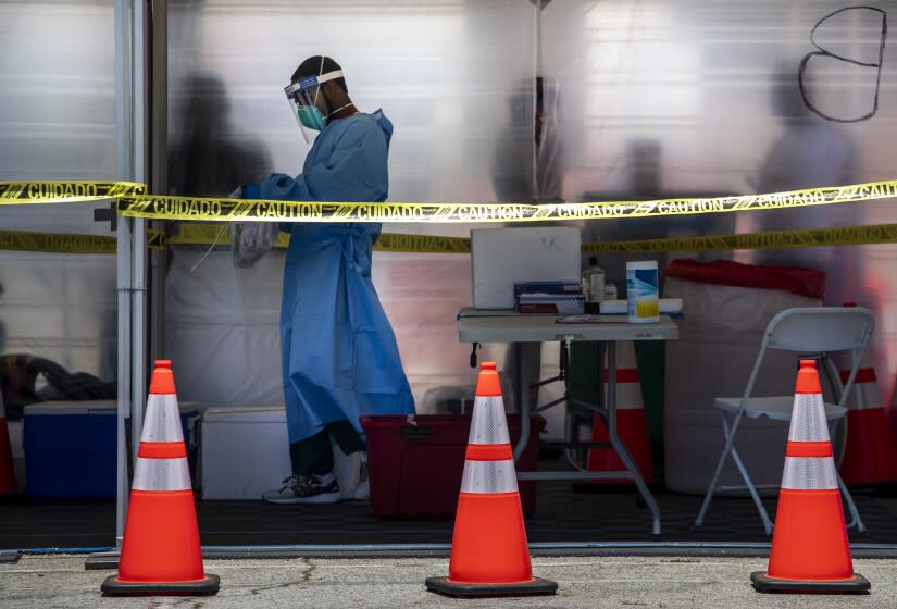 ENCINO, CA - JULY 23: EMT Travis Carr prepares COVID-19 tests for delivery to a lab at Balboa Sports Center on Thursday, July 23, 2020 in Encino, CA. (Brian van der Brug / Los Angeles Times)