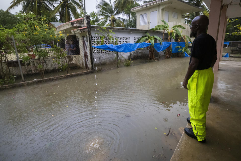 Un trabajador del municipio de Loiza llama a desalojar a los residentes por inundaciones inminentes por las lluvias del huracán Fiona, en Loiza, Puerto Rico, el domingo 18 de septiembre de 2022. (Foto AP/Alejandro Granadillo)