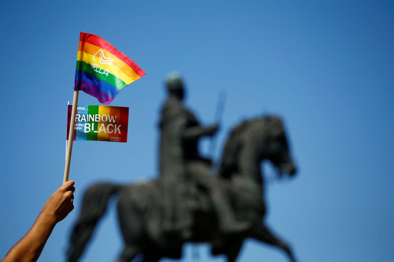 FILE PHOTO: A reveller holds flags during the annual Christopher Street Day gay pride parade in Cologne