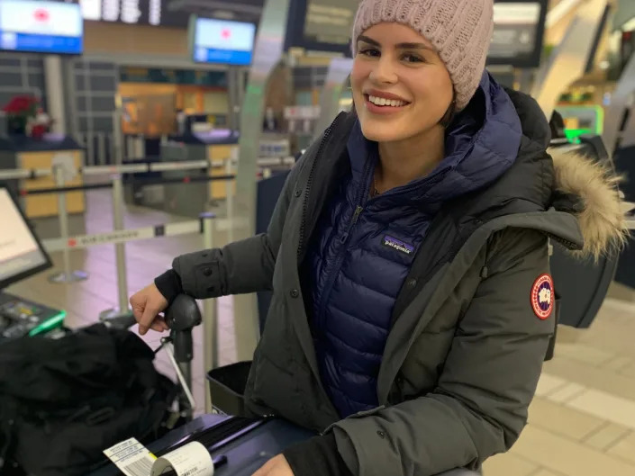 hilary standing with luggage at an airport