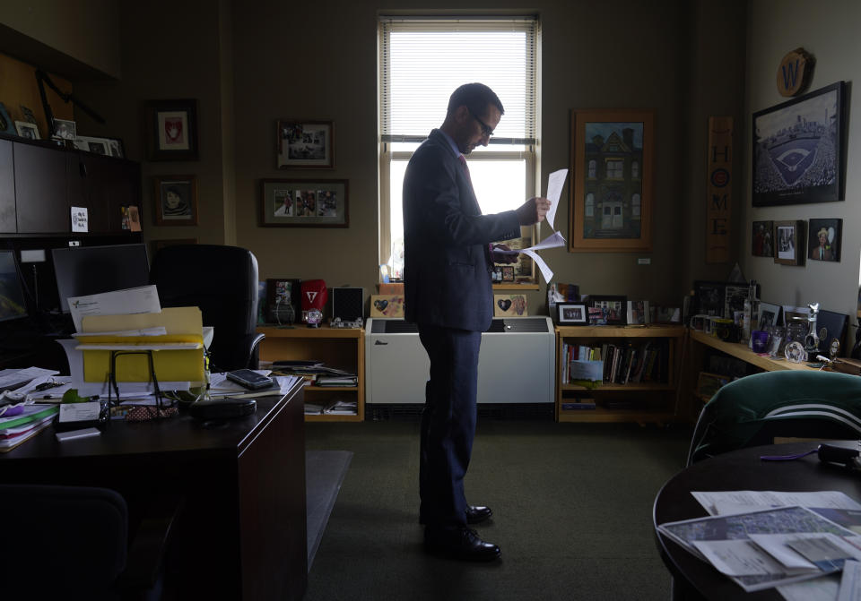 Rockford Mayor Tom McNamara poses for a portrait while looking over the city council docket Monday, Sept. 20, 2021, in Rockford, Ill. Money from the American Rescue Plan means the city can take a new approach to addressing violent crime in a city that has struggled with violence for years, especially during the pandemic. Rockford decided to spend part of a roughly $54 million federal windfall to overhaul its approach to juvenile crime, from hiring a data analyst to offering diversion programs for kids as young as 7. (AP Photo/Charles Rex Arbogast)