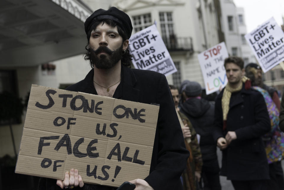  A protester is seen holding a placard that says Stone one of us face all of us during the demonstration. Protesters gathered outside of the luxury Dorchester hotel in London, UK which is owned by the Sultan of Brunei Hassanal Bolkia, to protest and condemn the new anti-LGBTIQ laws brought in by the Sultan. Under the new laws introduced in Brunei those found guilty of gay sex or adultery could be stoned to death. Some celebrity's in the world have voiced opposition to the regime and condemn the new laws and called for a boycott of hotels owned by the sultan. Protesters gathered outside Dorchester Hotel in London, UK which is owned by the Sultan of Brunei Hassanal Bolkia, to protest and condemn the new anti-LGBT laws brought in by Sultan. Under the new laws introduced in Brunei those found guilty of gay sex or adultery could be stoned to death. Some celebrity's in the world have voiced opposition to the regime and condemn the new laws and called for a boycott of hotels owned by sultan. (Photo by Andres Pantoja / SOPA Images/Sipa USA) 