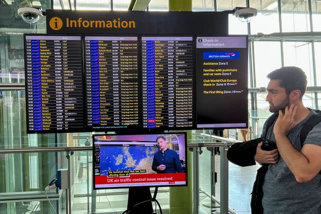 Passengers look at the departures board at Heathrow Airport.