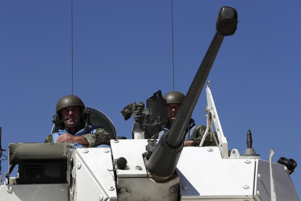 Irish UN peacekeepers sit on their armored personnel carrier as they patrol near the fields that burned on Sunday by the Israeli army shells in the southern Lebanese-Israeli border village of Maroun el-Ras, Lebanon, Monday, Sept. 2, 2019. The Lebanon-Israel border was mostly calm with U.N. peacekeepers patrolling the border Monday, a day after the Lebanese militant Hezbollah group fired a barrage of anti-tank missiles into Israel, triggering Israeli artillery fire that lasted less than two hours and caused some fires. (AP Photo/Hussein Malla)