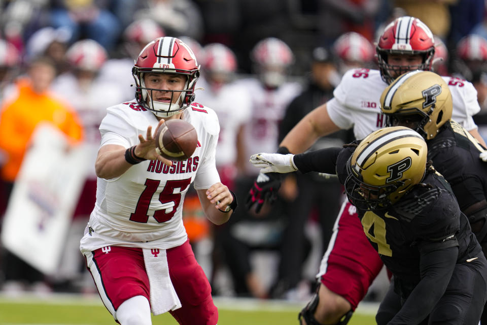 Indiana quarterback Brendan Sorsby (15) makes a pitch in front of Purdue linebacker Kydran Jenkins (4) during the first half of an NCAA college football game in West Lafayette, Ind., Saturday, Nov. 25, 2023. (AP Photo/Michael Conroy)
