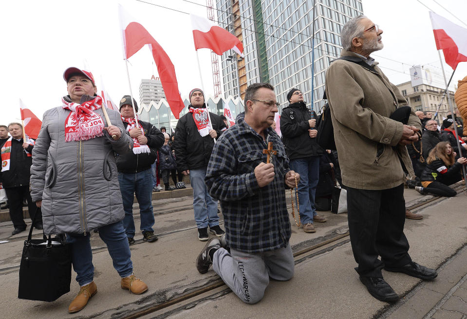 Men pray with rosaries before a march on Independence Day in Warsaw, Poland, Monday, Nov. 11, 2019. (AP Photo/Czarek Sokolowski)