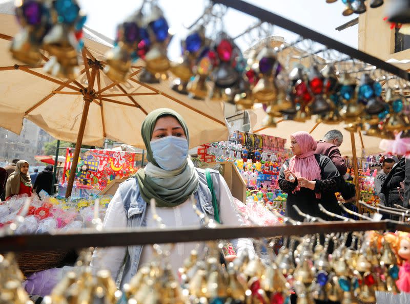 FILE PHOTO: A woman wearing a protective face mask amid concerns over the coronavirus disease (COVID-19) buys traditional Ramadan lanterns, called "fanous" at a stall, ahead of the Muslim holy month of Ramadan in Cairo, Egypt