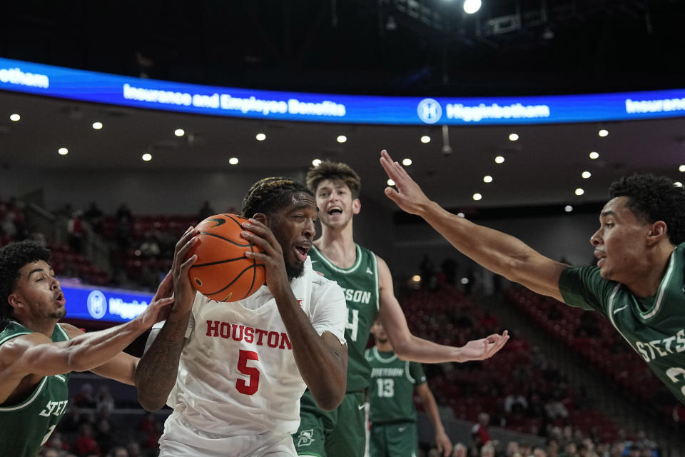 Houston's Ja'Vier Francis (5) grabs a rebound between Stetson's Tristan Gross (1) anbd Naeem Lewis, right, during the second half of an NCAA college basketball game Monday, Nov. 13, 2023, in Houston. (AP Photo/David J. Phillip)