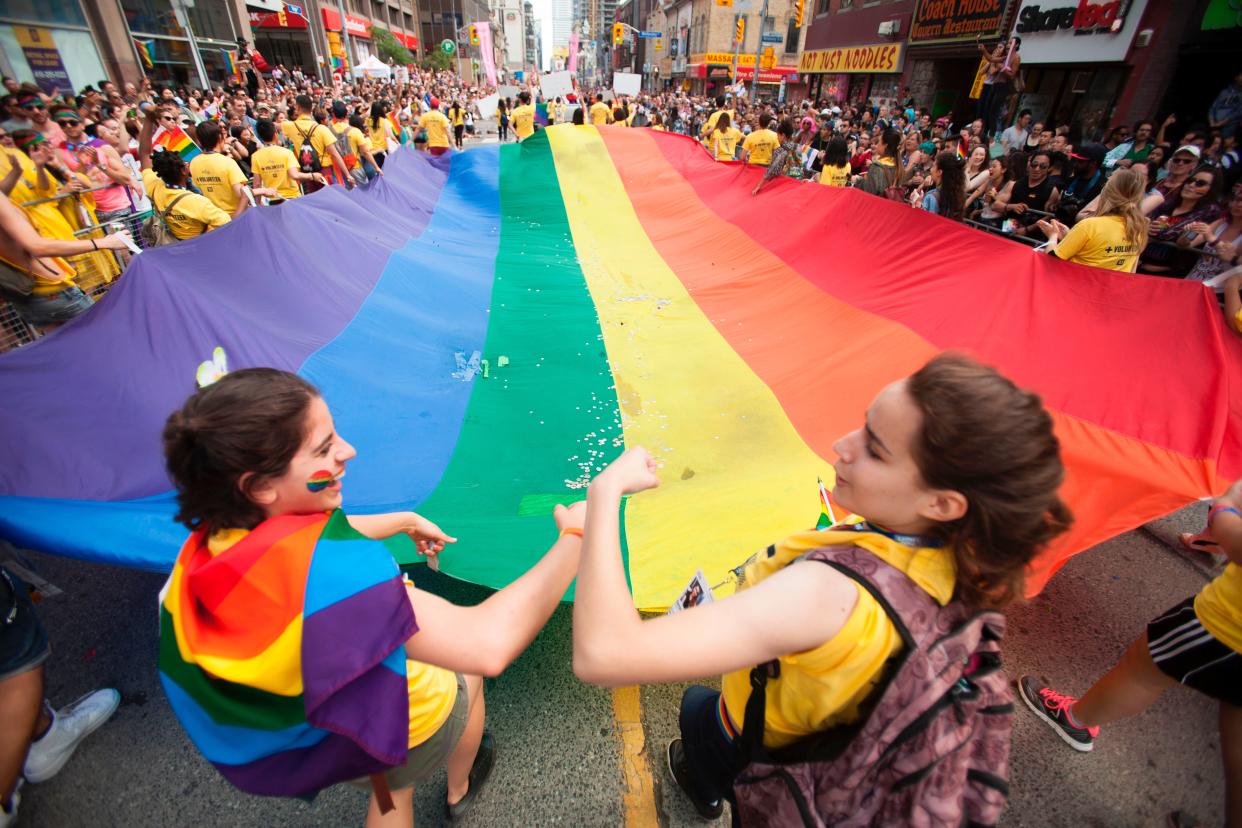 A giant pride flag is carried down Younge Street in Toronto, Ontario during the city's Pride Parade, 25 June 2017 ((AFP via Getty Images))