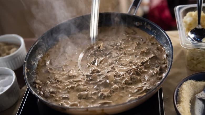 Steaming mushroom soup with metal spoon