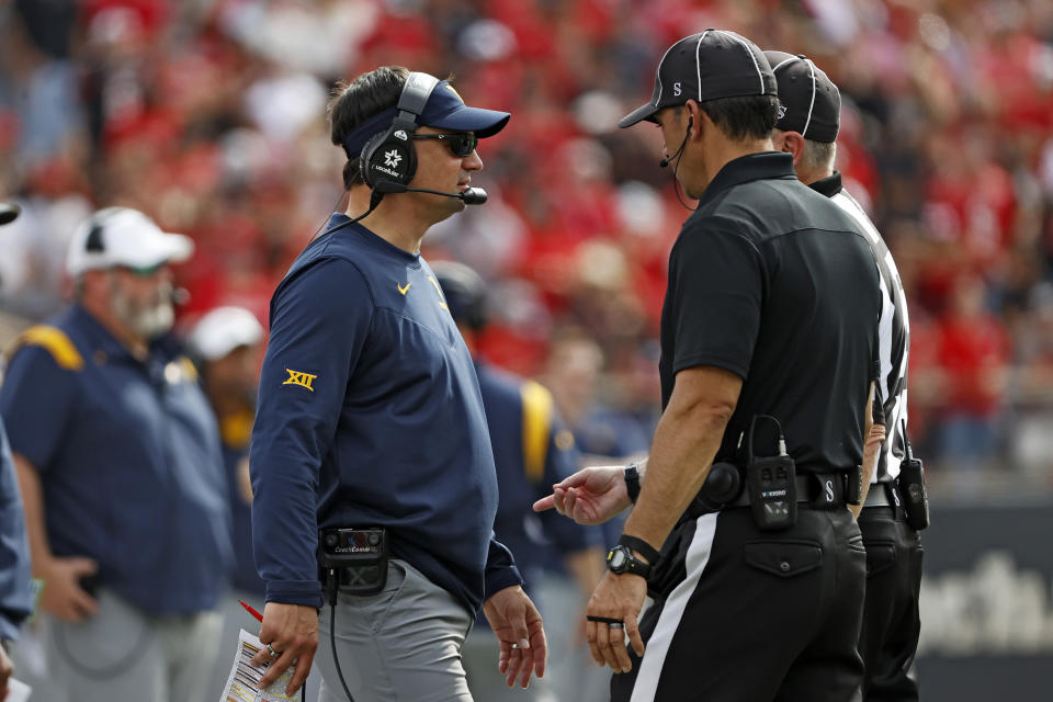 West Virginia coach Neal Brown talks to the officials after a penalty during the first half of an NCAA college football game against Texas Tech, Saturday, Oct. 22, 2022, in Lubbock, Texas. (AP Photo/Brad Tollefson)