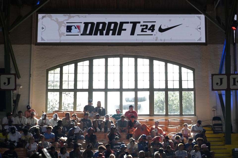 Attendees look on during the MLB baseball draft at the Cowtown Coliseum in Fort Worth, Texas, Sunday, July 14, 2024. (AP Photo/LM Otero)