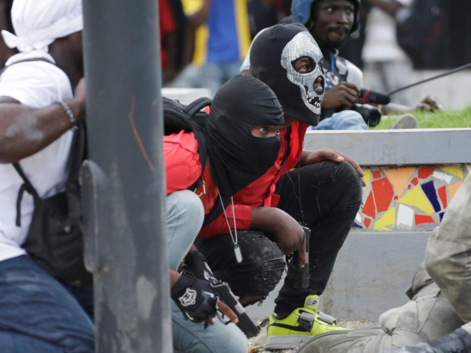 Protesters take cover during a shooting at a protest called by members of the police, in Port-au-Prince, Haiti February 23, 2020.