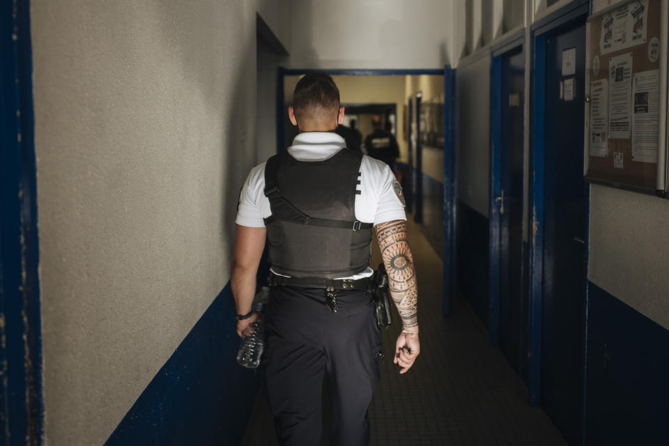 Police officer Victor walks inside the police station of the Paris suburb of Sarcelles, Tuesday, June, 15, 2021. The police station in Sarcelles was attacked in February by youths who launched noisy fireworks and threw stones, according to authorities. No injuries were reported but the attack was one of several targeting police stations that have heightened anxiety in police ranks. (AP Photo/Lewis Joly)