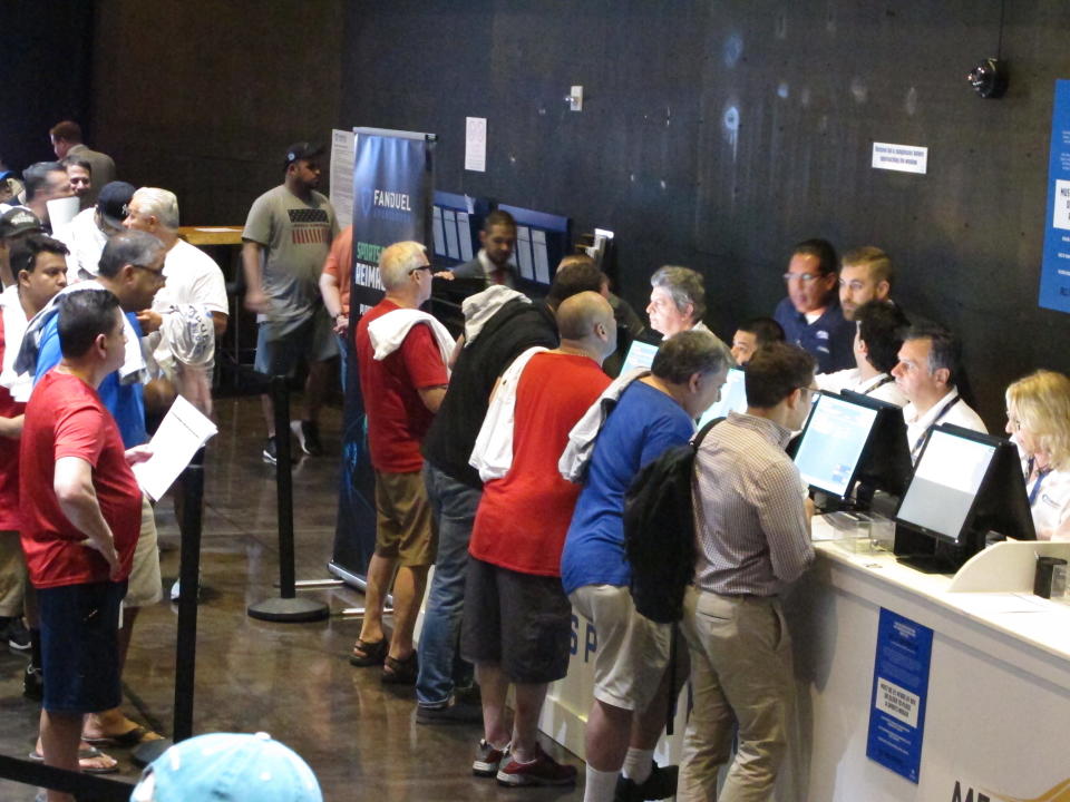 This July 14, 2018 file photo shows gamblers placing bets on sports events at the FanDuel sports book at the Meadowlands Racetrack in East Rutherford, N.J., on the day it opened. On Nov. 30, 2018, FanDuel paid out bets on Alabama to win the national college football championship a month before the game is played. (AP Photo/Wayne Parry, File)