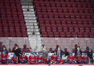 Montreal Canadiens players and coaching staff look on from the bench against a backdrop of empty seats during during second-period NHL hockey game action against the Philadelphia Flyers in Montreal, Thursday, Dec. 16, 2021. (Graham Hughes/The Canadian Press via AP)