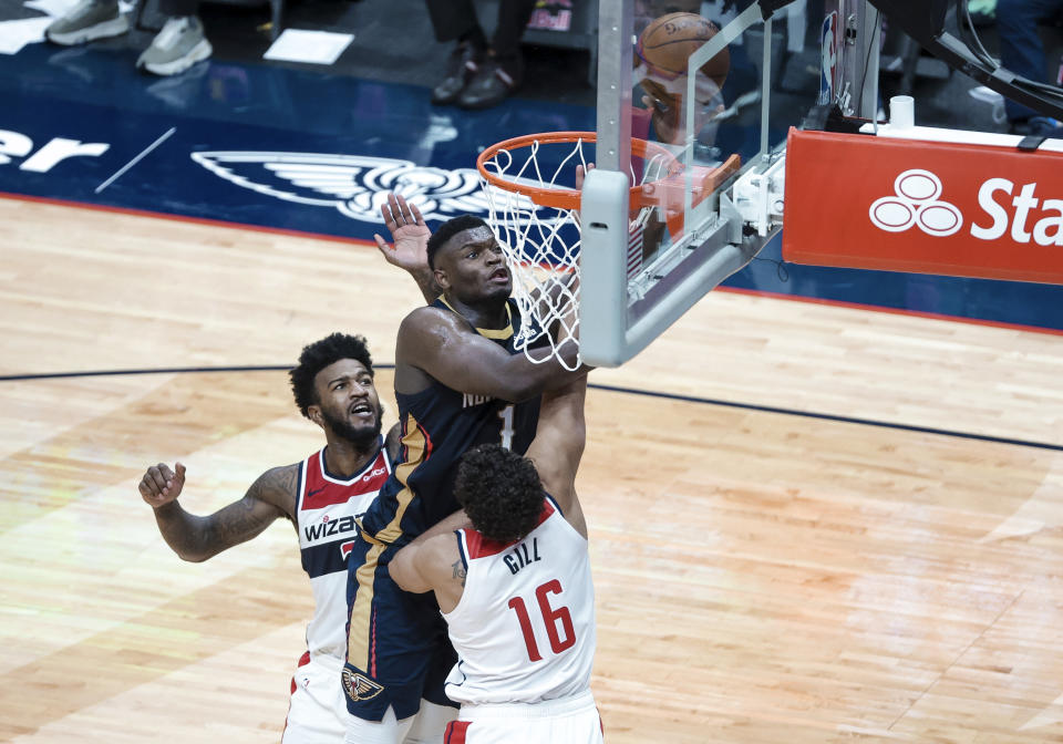 New Orleans Pelicans forward Zion Williamson (1) shoots over Washington Wizards forward Anthony Gill (16) and forward Jordan Bell (7) in the fourth quarter of an NBA basketball game in New Orleans, Wednesday, Jan. 27, 2021. (AP Photo/Derick Hingle)