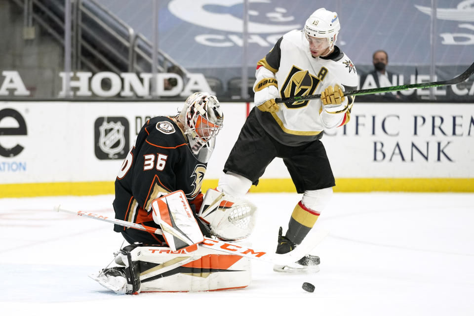 Anaheim Ducks goaltender John Gibson, left, deflects a shot as Vegas Golden Knights right wing Reilly Smith stands in front of him during the first period of an NHL hockey game Saturday, Feb. 27, 2021, in Anaheim, Calif. (AP Photo/Mark J. Terrill)