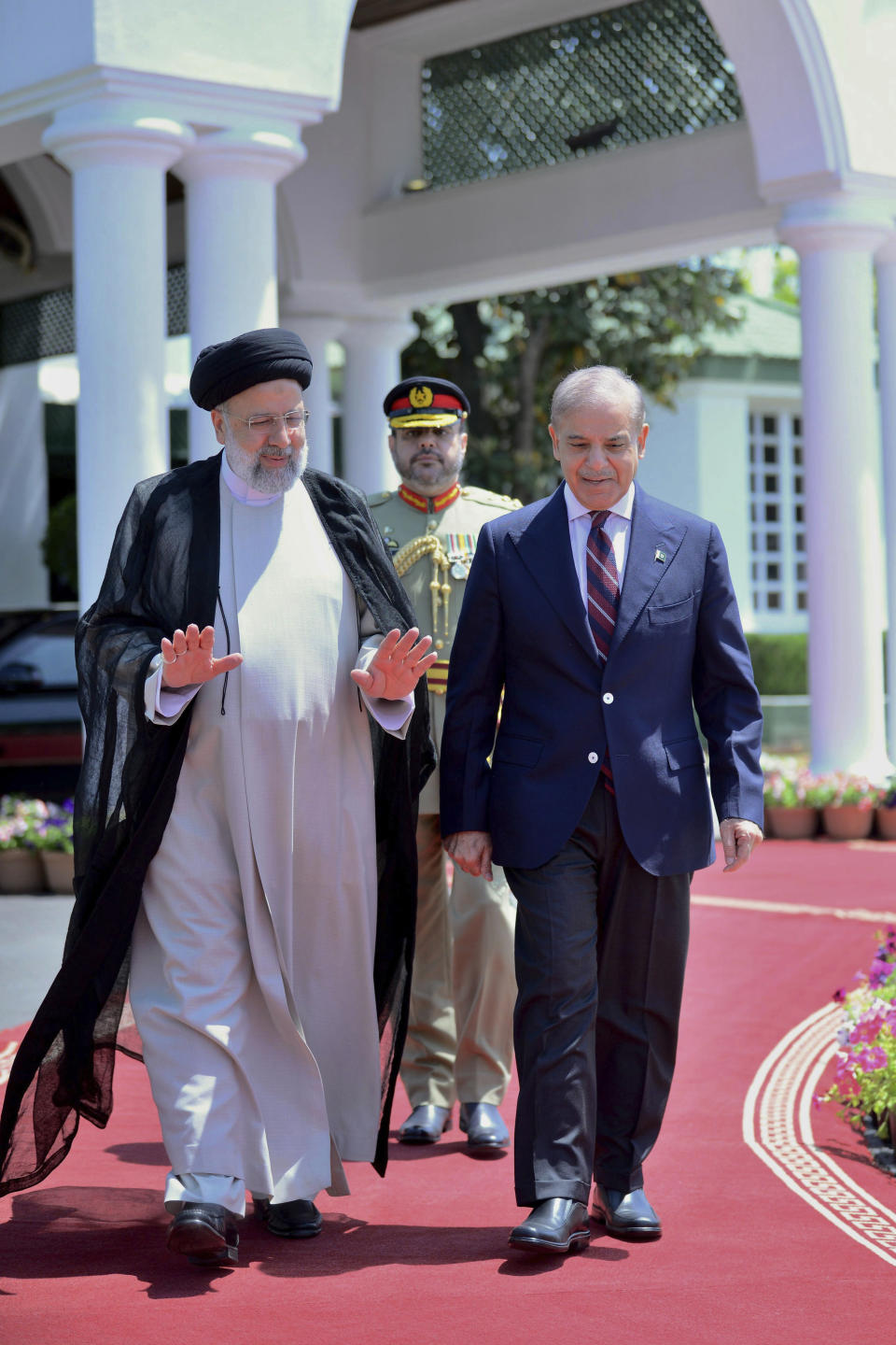 In this photo released by Prime Minister Office, Iranian President Ebrahim Raisi, left, walks with Pakistan's Prime Minister Shehbaz Sharif during a welcome ceremony in the prime minister house in Islamabad, Pakistan, Monday, April 22, 2024. (Prime Minister Office via AP)