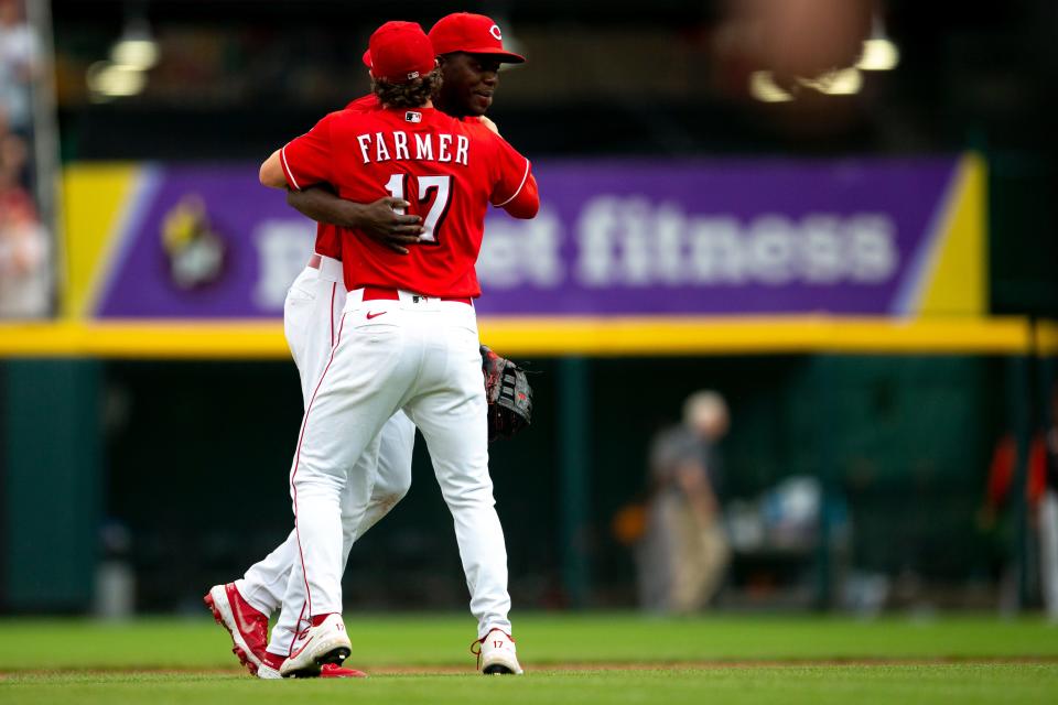 Cincinnati Reds right fielder Aristides Aquino (44) hugs Cincinnati Reds shortstop Kyle Farmer (17) after making a throw for the last out to end the MLB game between the Cincinnati Reds and the San Francisco Giants at Great American Ball Park in Cincinnati, Saturday, May 28, 2022.