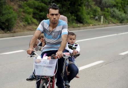 Migrants from Syria ride their bicycles near the Greek border in Macedonia June 17, 2015. REUTERS/Ognen Teofilovski