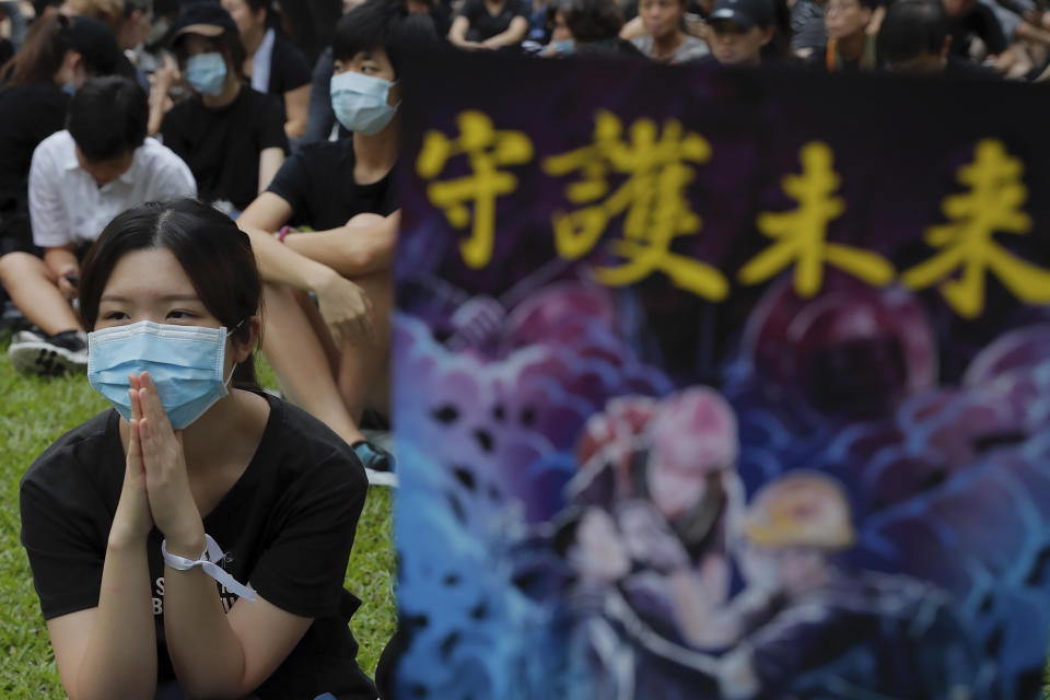 Protesters gather at Belcher Bay Park to take part in an anti-extradition bill protest in Hong Kong, Sunday, Aug. 4, 2019. Protesters held two more rallies Sunday after Hong Kong police announced more than 20 people were arrested following clashes at an earlier demonstration, adding to increasingly tense confrontations with the Chinese territory's government. The sign reads "Protect the future." (AP Photo/Kin Cheung)