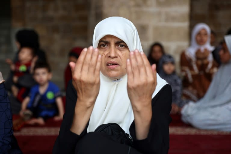 a Palestinian woman performs the Eid al-Adha morning prayer in the courtyard of Gaza City's historic Omari Mosque that was heavily damaged in Israeli bombardment (Omar AL-QATTAA)