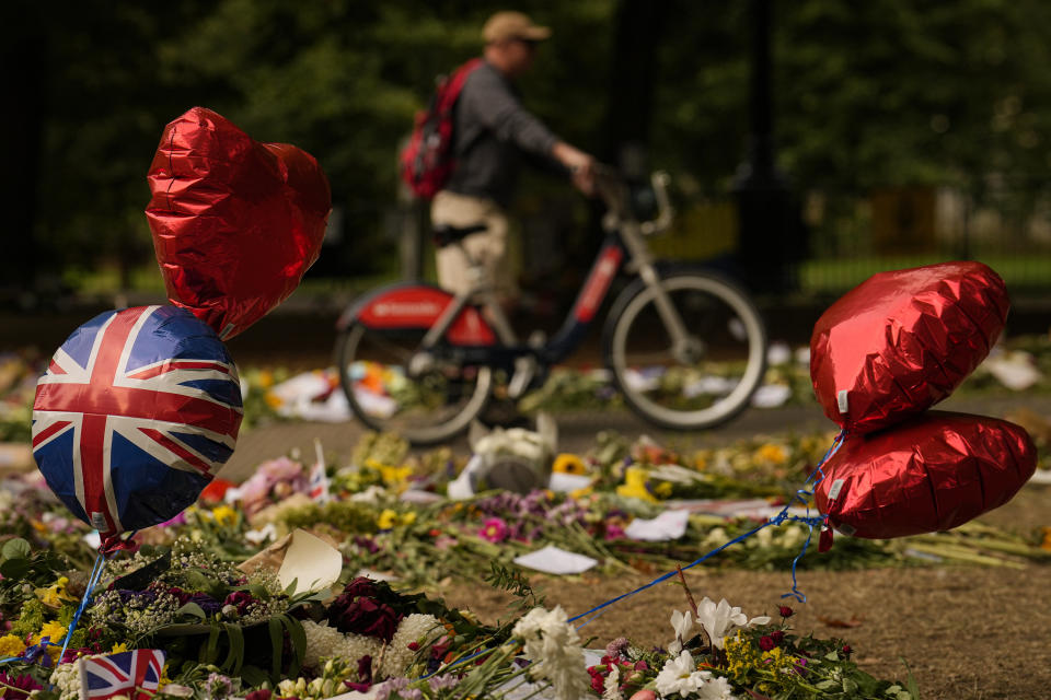 People bring floral tributes to Queen Elizabeth II, the day after her funeral in London's Green Park, Tuesday, Sept. 20, 2022. The Queen, who died aged 96 on Sept. 8, was buried at Windsor alongside her late husband, Prince Philip, who died last year. (AP Photo/Vadim Ghirda)