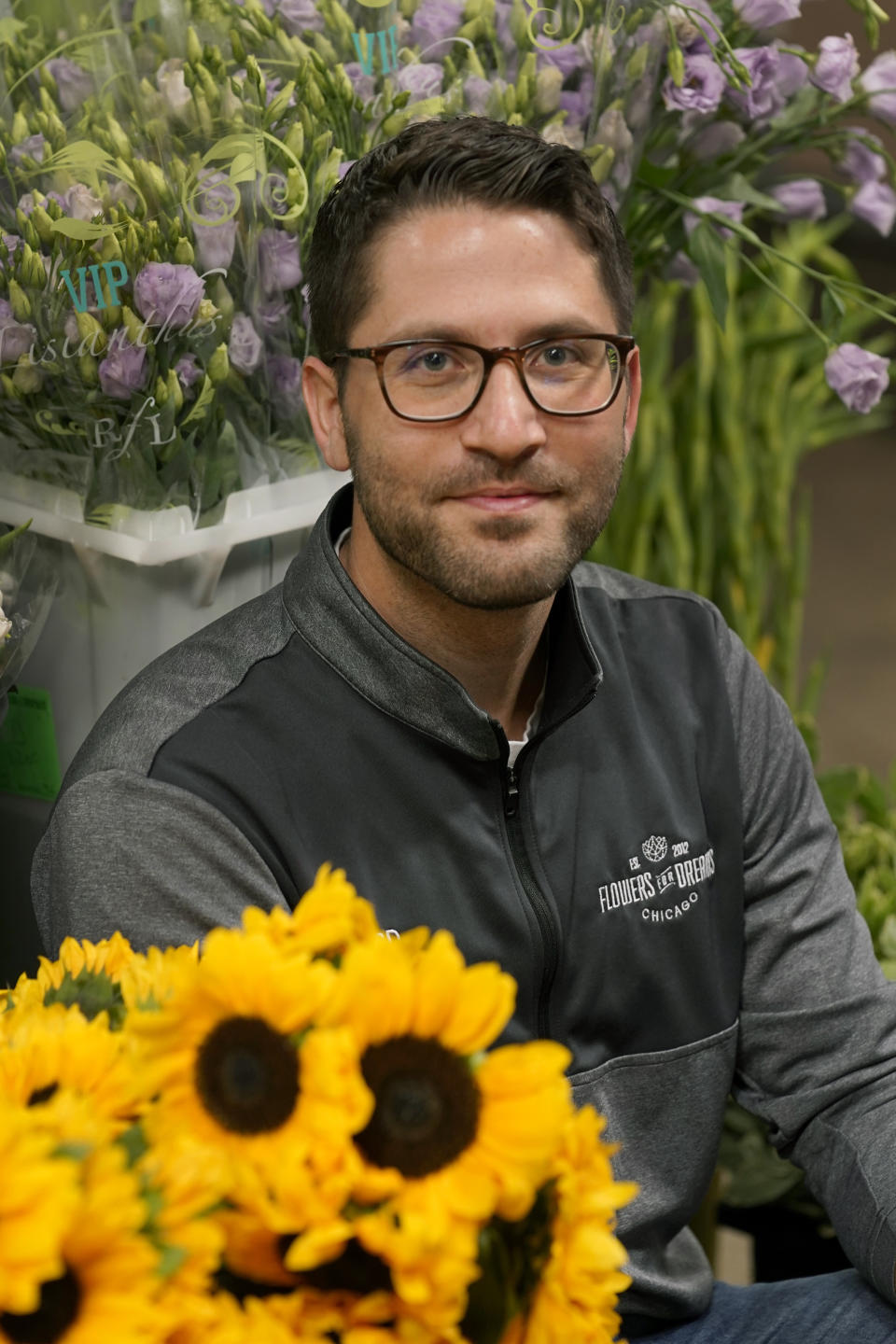 Steven Dyme, owner of Flowers for Dreams, poses for a portrait at his warehouse Friday, July 23, 2021, in Chicago. Dyme says the $15 minimum made it much easier to staff up when the economy reopened this spring and demand for flowers, particularly for weddings, soared. The company has four locations, including its headquarters in Chicago, one in Milwaukee, and two in Detroit. (AP Photo/Charles Rex Arbogast)