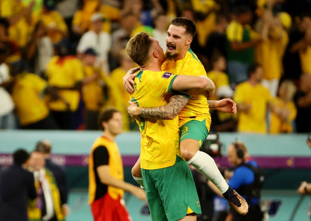 Australian players celebrate their dramatic victory over Denmark (Reuters)