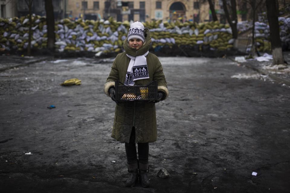 Natalia poses for a picture in front of a barricade as she distributes hot soup to anti-government protesters in Kiev