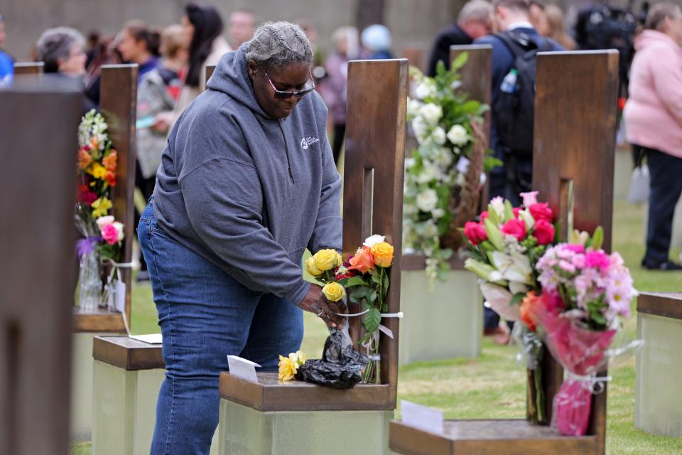 Ida Bolden places roses from her rose bush on the chair of her cousin, Lola Bolden, after the ceremony.