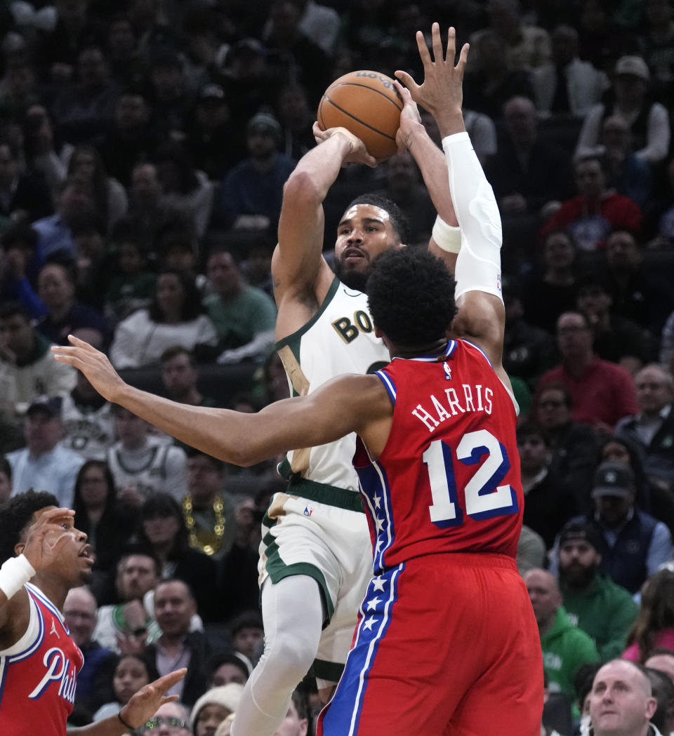 Boston Celtics forward Jayson Tatum, rear, takes a shot over Philadelphia 76ers forward Tobias Harris (12) during the first half of an NBA basketball game, Tuesday, Feb. 27, 2024, in Boston. (AP Photo/Charles Krupa)