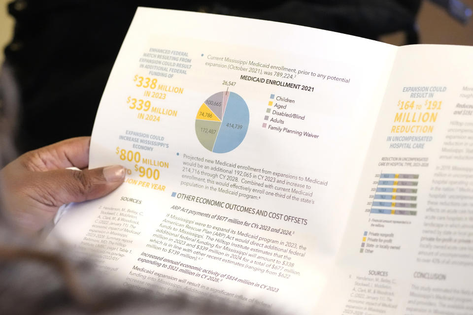 A Mississippi state legislator reads over a brief on the economic impact of Medicaid expansion in Mississippi, during a meeting of the Mississippi House Medicaid Committee at the state Capitol in Jackson, Miss., Tuesday, Feb. 20, 2024. (AP Photo/Rogelio V. Solis)