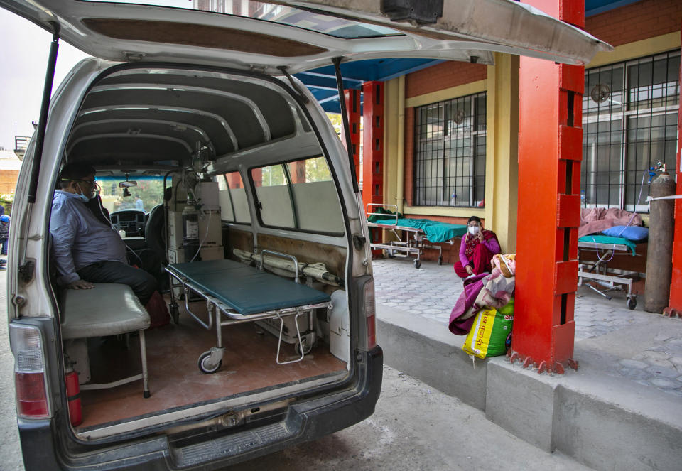 A COVID-19 patient receives oxygen in an ambulance outside an emergency ward as he waits for a bed to be allotted at a hospital in Kathmandu, Nepal, Thursday, May 6, 2021. Nepal's main cities and towns including the capital Kathmandu has been in lockdown since last month as the number coronavirus cases and deaths continue to rise. (AP Photo/Niranjan Shrestha)