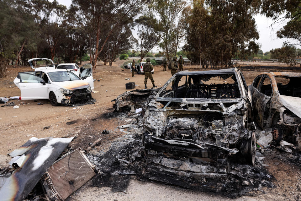 Soldados israelíes inspeccionan vehículos quemados en un estacionamiento cerca de donde se celebraba un festival antes del ataque de Hamás que dejó al menos 260 muertos, junto a la frontera de Israel con Gaza, en el sur de Israel. La imagen fue tomada el 10 de octubre de 2023 (REUTERS/Ronen Zvulún)